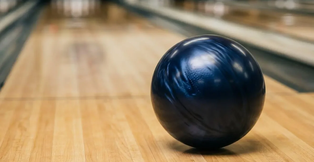 Boule de bowling en pleine rotation avec effet hook marqué sur piste huilée