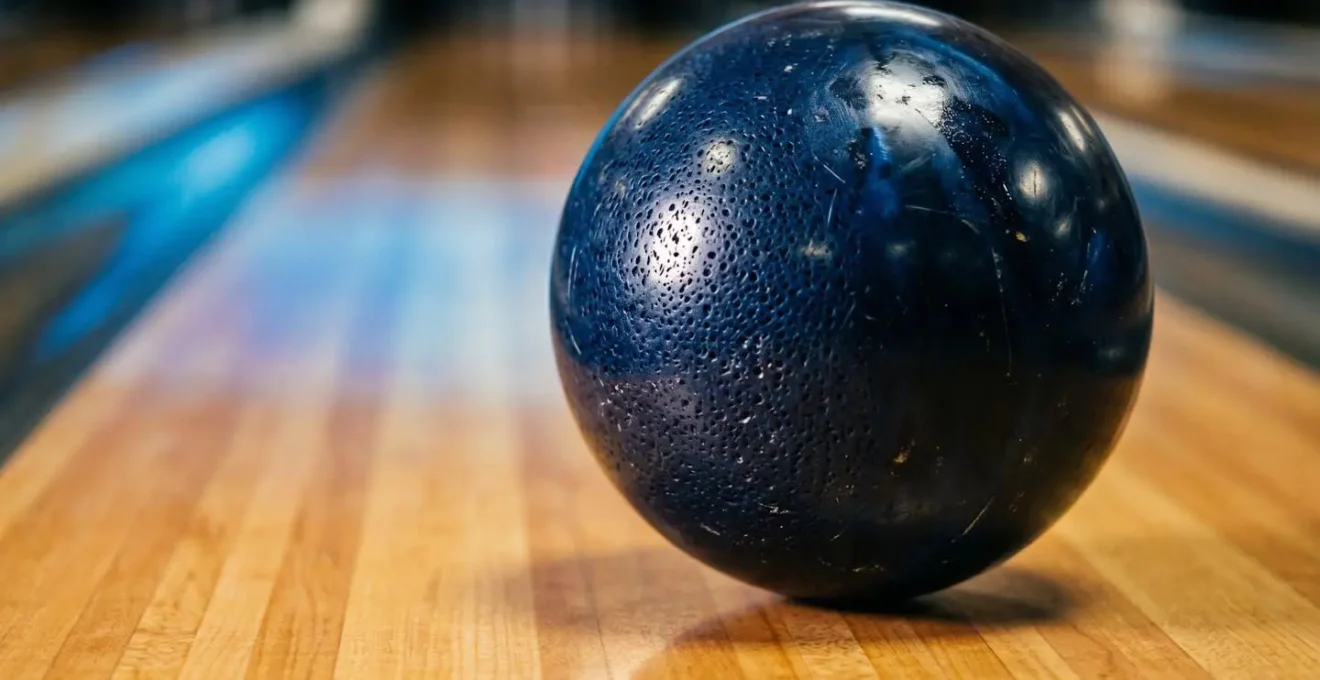 Gros plan d'une boule de bowling en plein mouvement montrant une rotation rapide et dynamique sur la piste