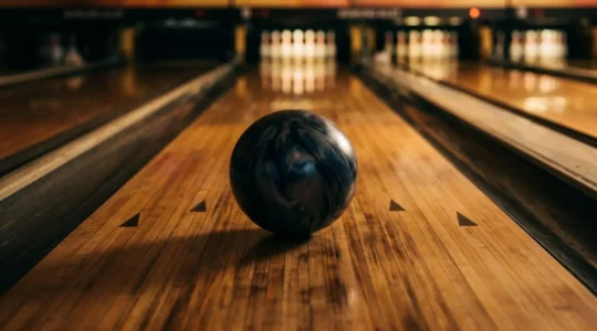 Une boule de bowling en mouvement sur la piste capturant l'instant de concentration et de détente