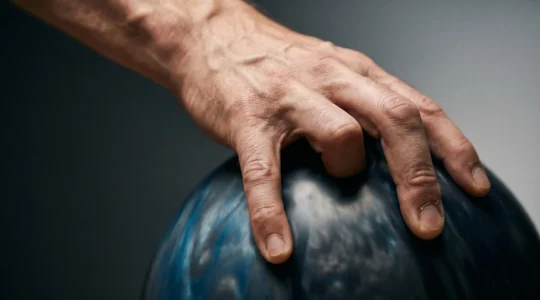 Gros plan sur une main de joueur de bowling effectuant un mouvement de rotation avec les doigts