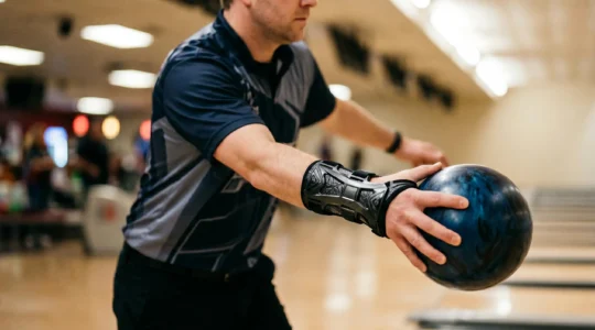 Joueur de bowling en position de lâcher avec support de poignet rigide