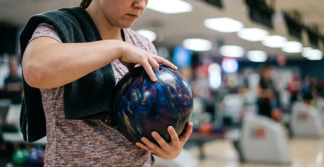 Joueur de bowling en position de concentration avant le lancer, ambiance épurée et focalisée