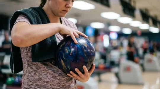 Joueur de bowling en position de concentration avant le lancer, ambiance épurée et focalisée