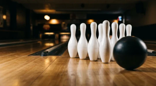 Vue rapprochée de quilles de bowling au moment de l'impact, avec mouvement et dynamisme